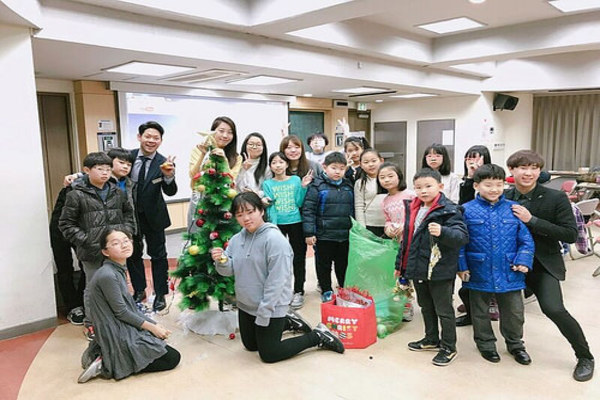 초등학생들이 크리스마스 트리를 장식하고있다